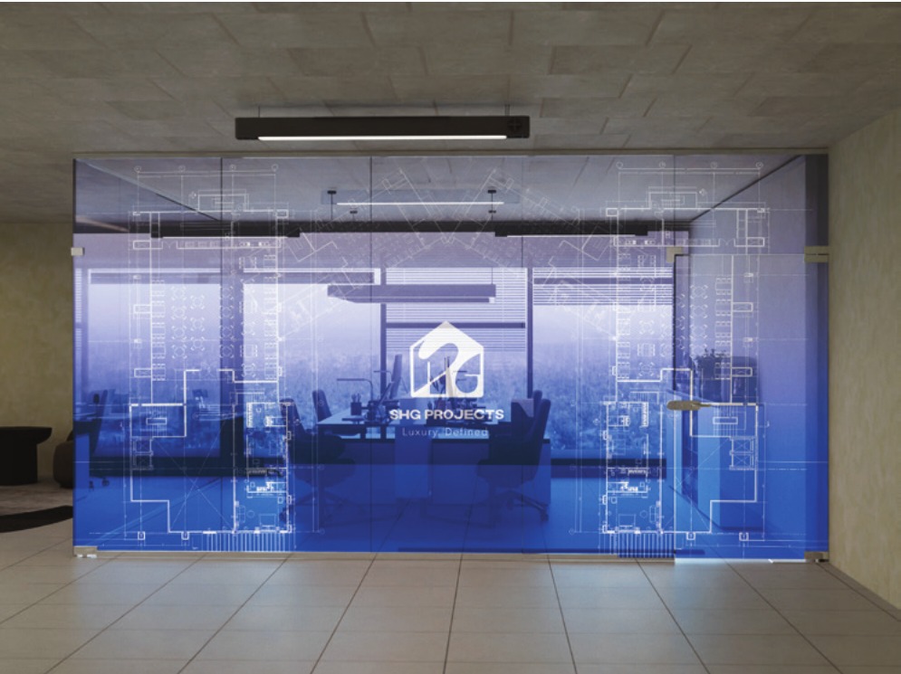 Interior office glass partition graphic with a semi-transparent blue architectural blueprint overlay and centred SHG Projects branding